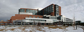 Photo shows the modern Childrens Hospital in Denver, it is expansive and made of red brick with matte chrome and windows. 